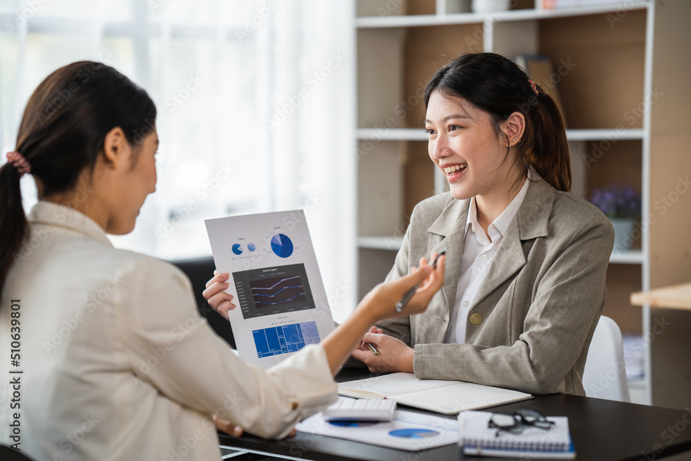 两位女商人在现代办公室举行非正式会议，导师帮助学徒解释公司