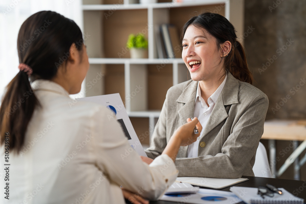 两位女商人在现代办公室举行非正式会议，导师帮助学徒解释公司