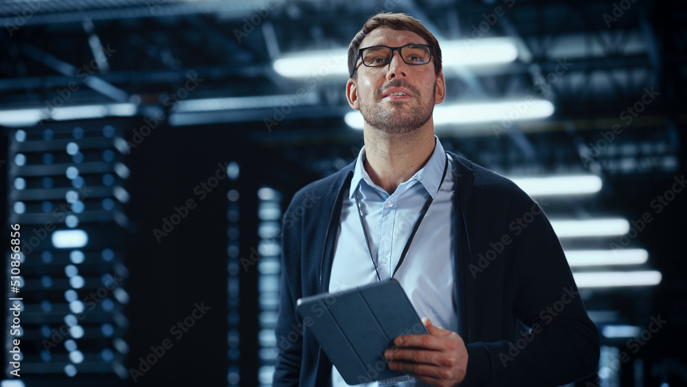 Male IT Specialist Walks Between Row of Operational Server Racks in Data Center. Engineer Uses Table