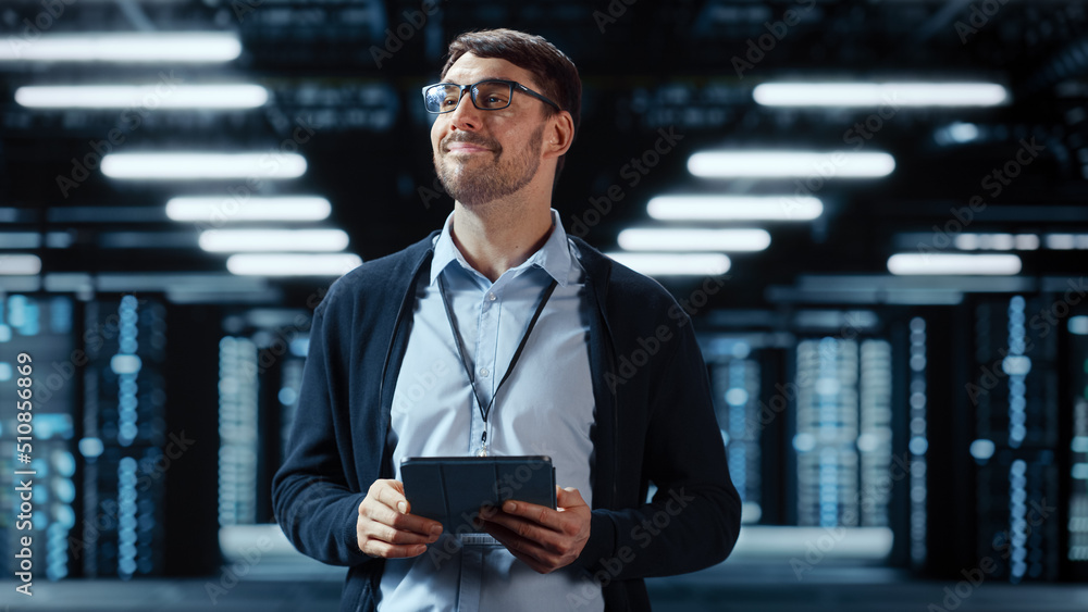 Male IT Specialist Walks Between Row of Operational Server Racks in Data Center. Engineer Uses Table