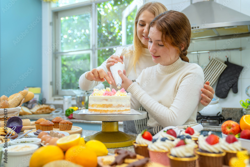 Mother and daughter happily making cakes and bakeries. It is an activity that is done in the family 