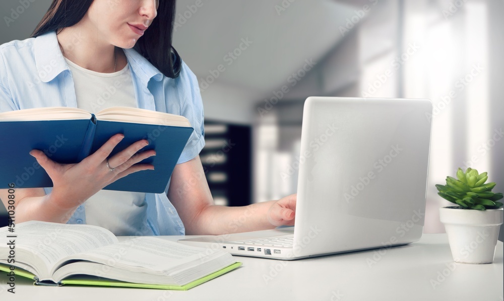 Woman working at the desktop with various items at home.