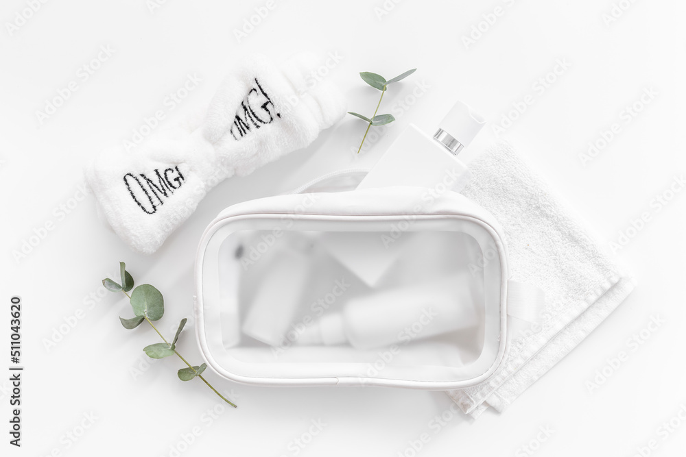 Cosmetic bag full of white cosmetic products and accessories, top view