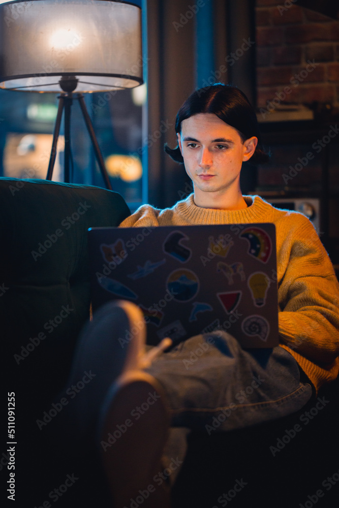 Vertical Screen: Young Handsome Man Working from Home on Laptop Computer in Stylish Loft Apartment i