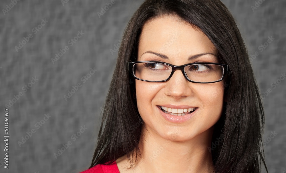 Beautiful face of young woman on grey wall. Successful happy woman.