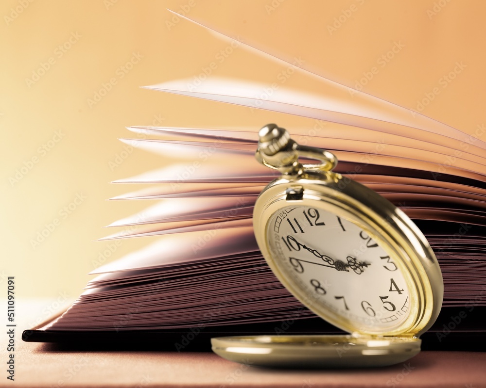 Beautiful old clock, old book on the desk