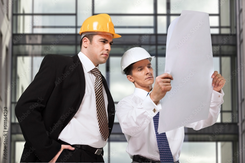 Engineer or architect with building plan at construction site, business, building, industry, people 