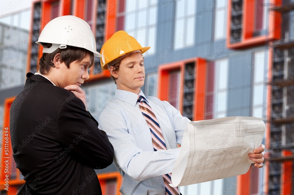 Engineer or architect with building plan at construction site, business, building, industry, people 