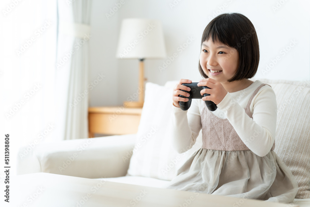 リビングでテレビゲームをプレイする女の子