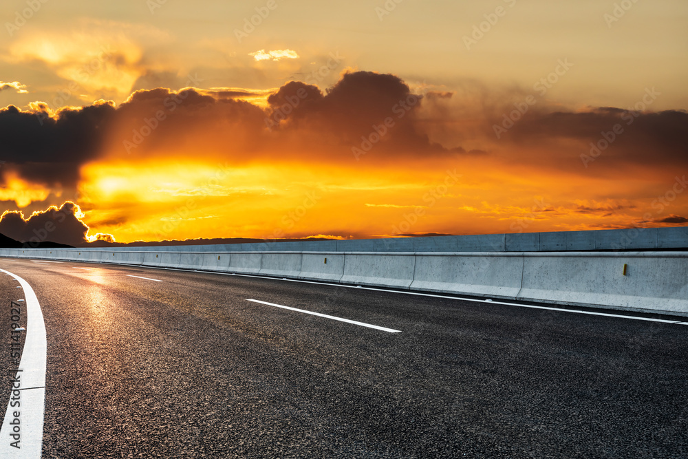 日出时的柏油路和天空云朵。道路和天空背景。