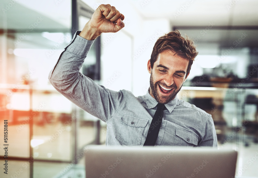 Its a victory worth celebrating. Shot of a handsome young businessman doing a fist pump while workin