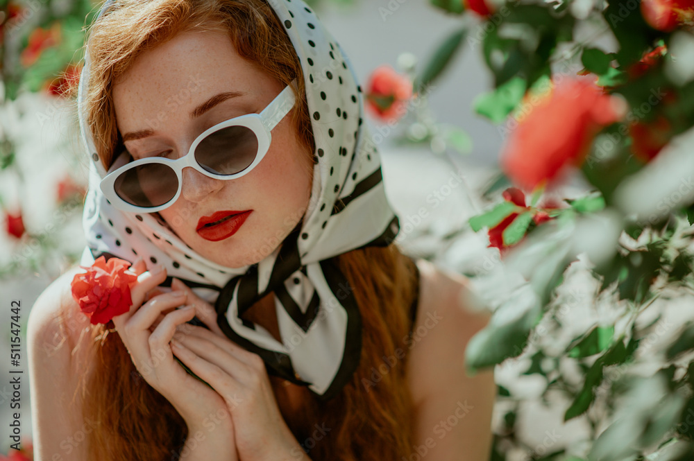 Fashionable confident woman wearing retro style sunglasses, polka dot print headscarf. Close up outd