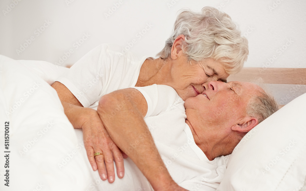 Rise and shine my love. Shot of a senior woman giving her husband a kiss in the morning.