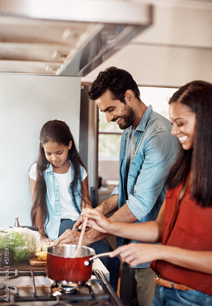 Time to cook, time to bond. Shot of a happy young family preparing a meal in the kitchen together at