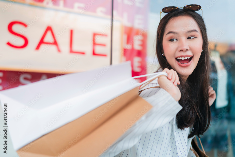 Happy smiling asian woman girls holding bunch of shopping bags,female returning home after shopping 