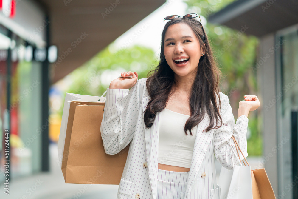 beautiful asia woman female pleased positive casual shopping hand hold paper bags happy woman enjoy 