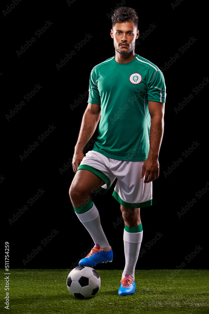 Ready for kick-off. Full length studio shot of a handsome young soccer player isolated on black.