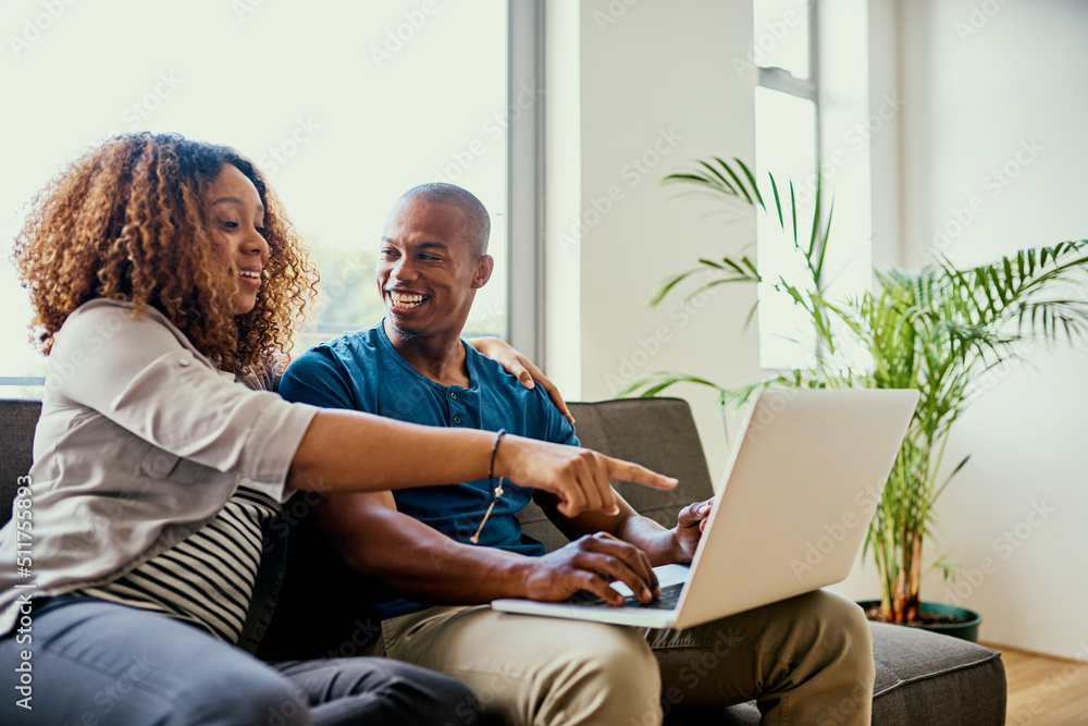 Lets watch this show next. Shot of a young couple using a laptop together at home.