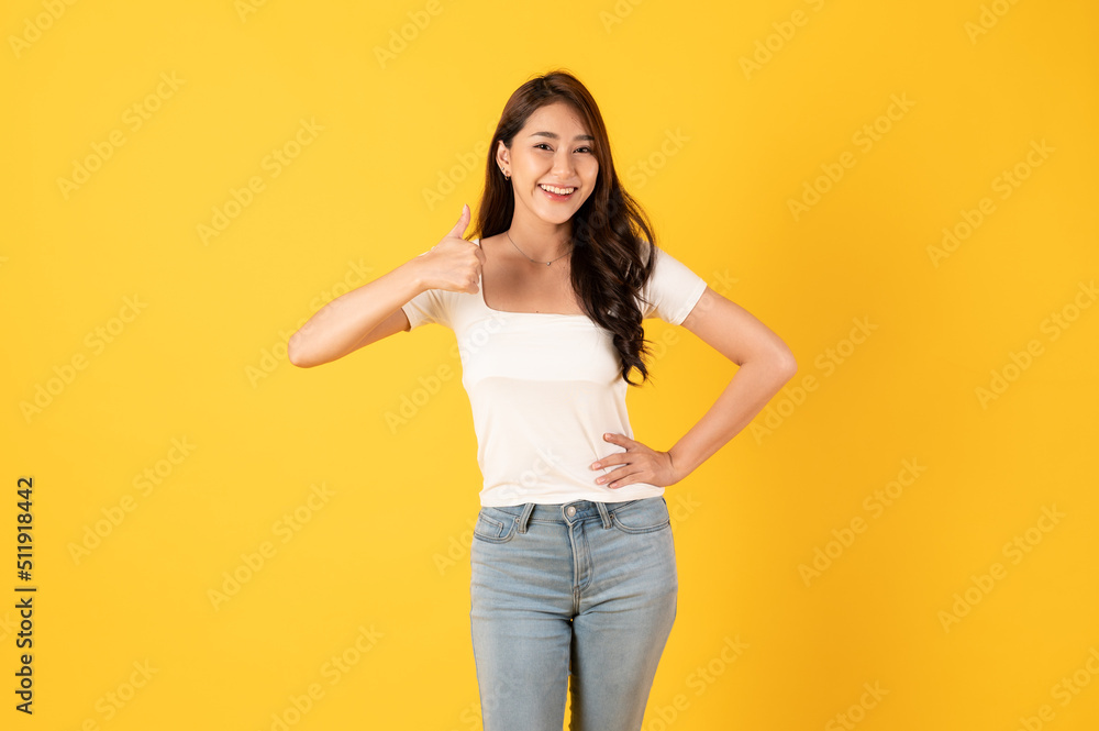 Smiling asian woman white shirt on yellow background with thumbs up show appreciate