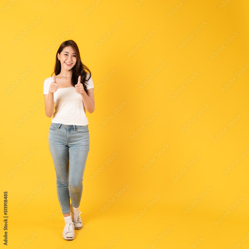 Smiling asian woman white shirt on yellow background with thumbs up show appreciate