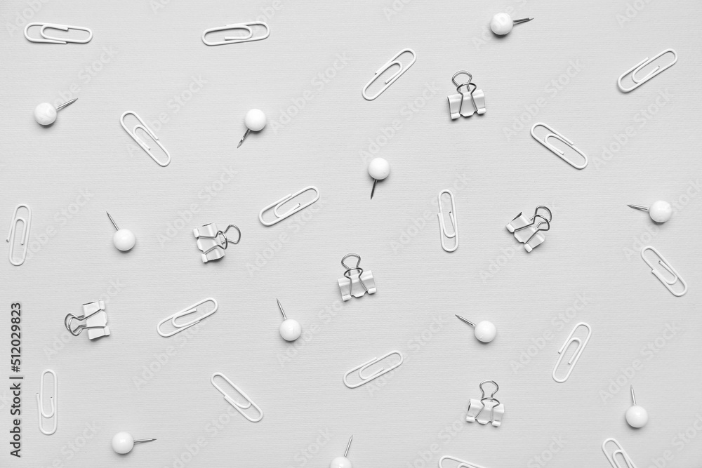 Different paper clips and pins on light background