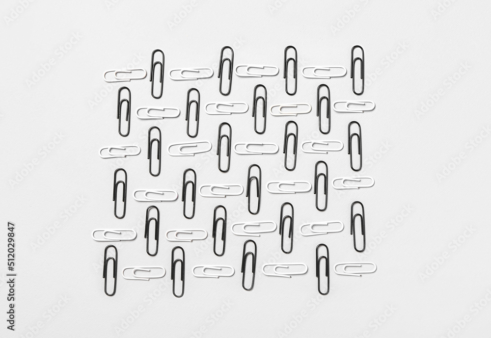 Black and white paper clips on light background