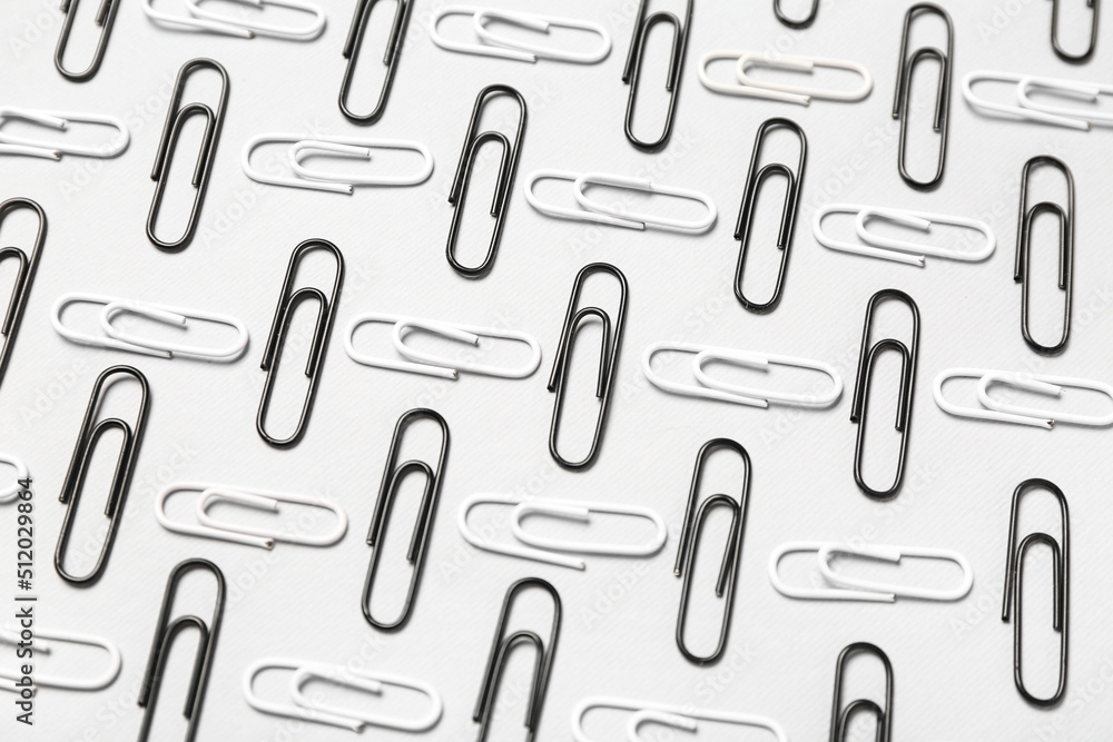 Black and white paper clips on light background