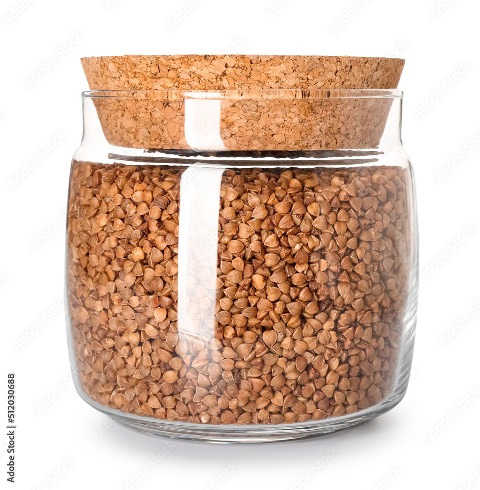 Jar with buckwheat grains on white background