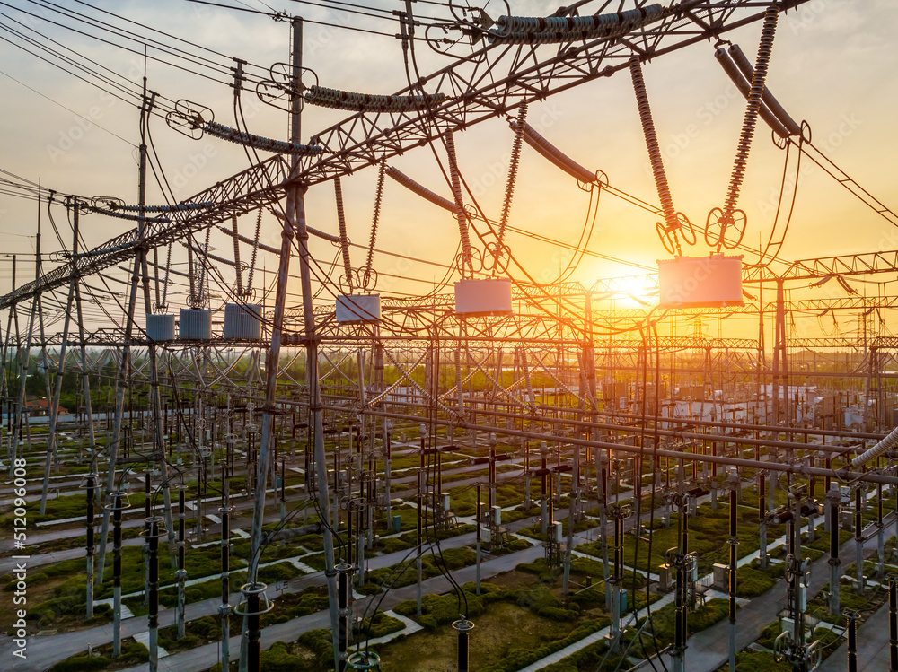 High voltage power tower in substation. Transmission power line. Electricity pylons and sky clouds b