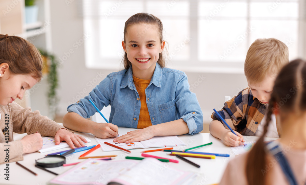 Diligent girl studying near classmates