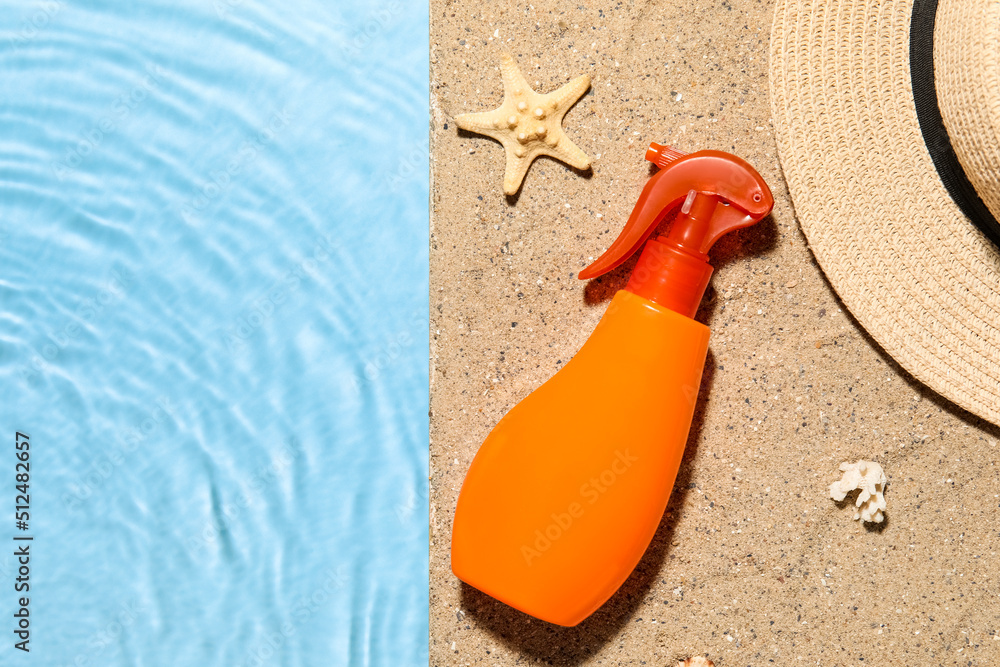 Spray bottle of sunscreen cream with hat on edge of swimming pool