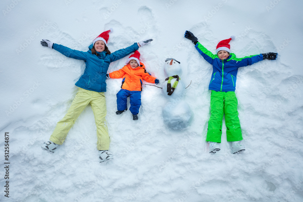 Family in snow together with snowman wear Santa hats top view