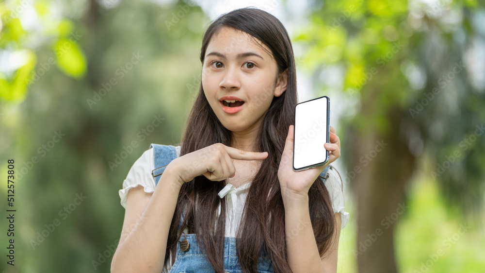 公园里使用智能手机的体贴微笑的女人，一位年轻迷人的商业女性的画像checki