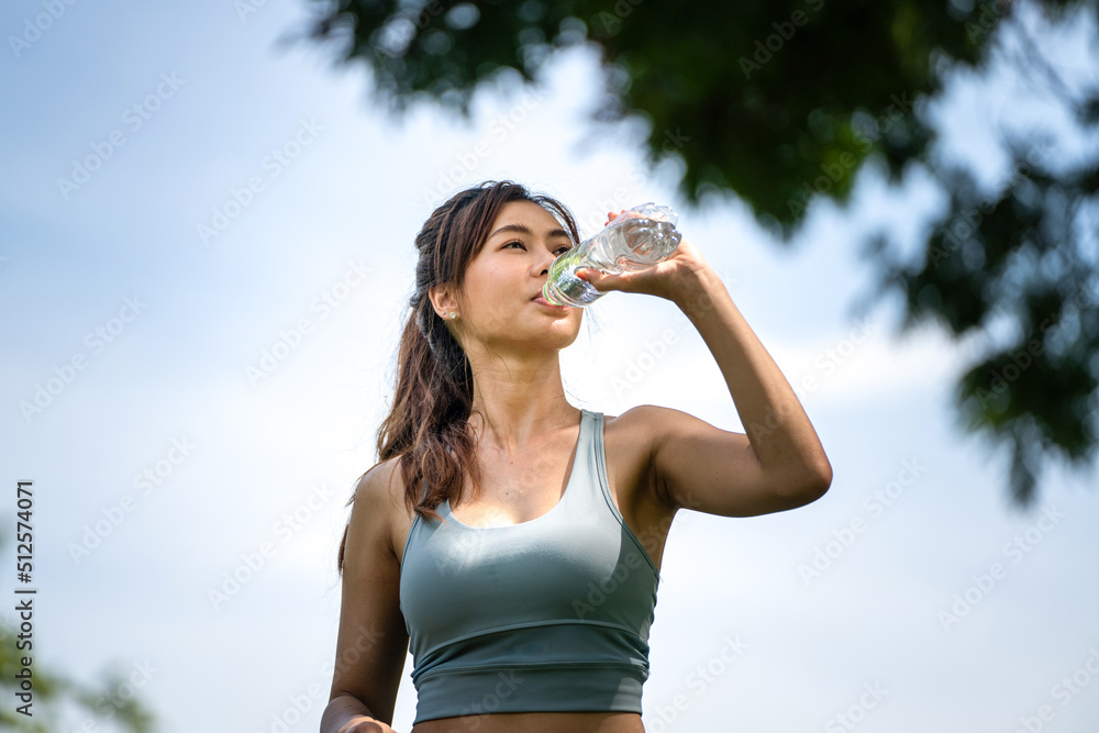 斯波尔夏季公园里，一个健身的女人在喝水，一个年轻口渴的女人在用瓶子喝水