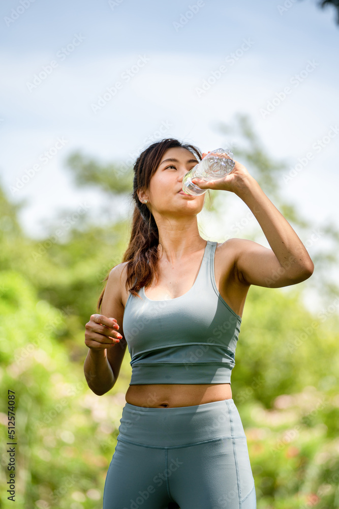 斯波尔夏季公园里，一个健身的女人在喝水，一个年轻口渴的女人在用瓶子喝水