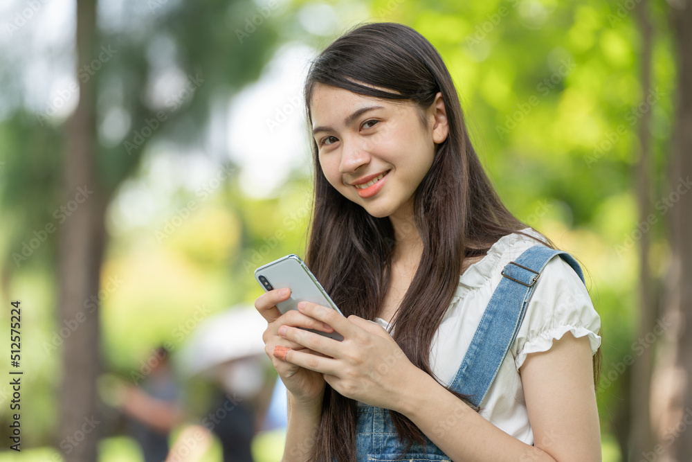 Thoughtful smile woman in park using smart phone, Portrait of a young charming business woman checki