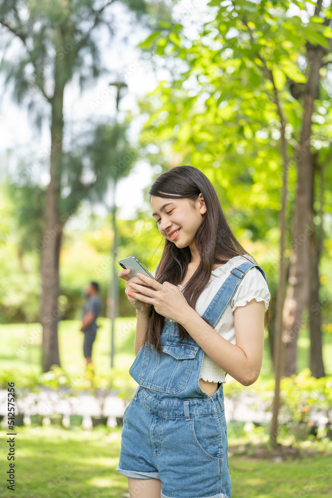 Thoughtful smile woman in park using smart phone, Portrait of a young charming business woman checki