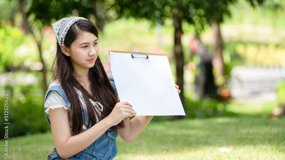 迷人的女孩，在阳光明媚的夏日，坐在公园的格子布上，用水彩完成