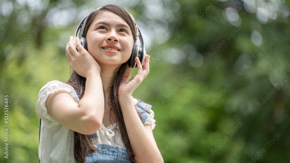 身穿米色衬衫的美丽年轻女子在绿城公园背景中摆姿势，微笑女孩Listenin