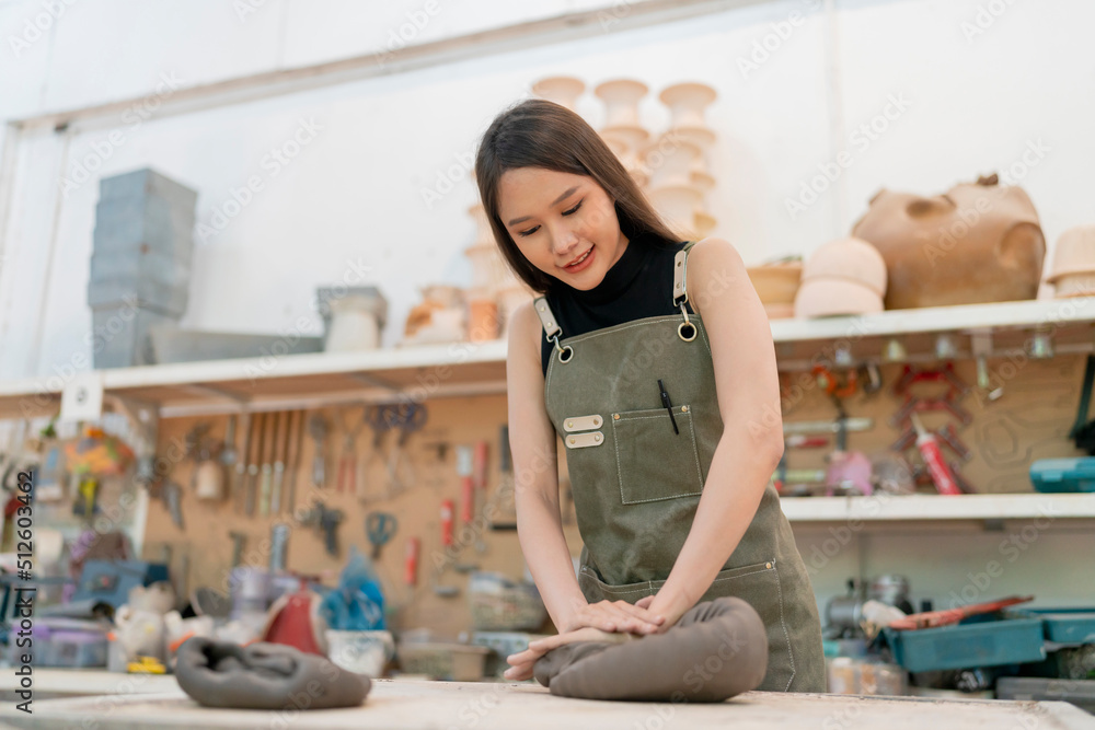 Asian Young woman female artist wear apron making clay vase bowl Beautiful young sculptor creates a 