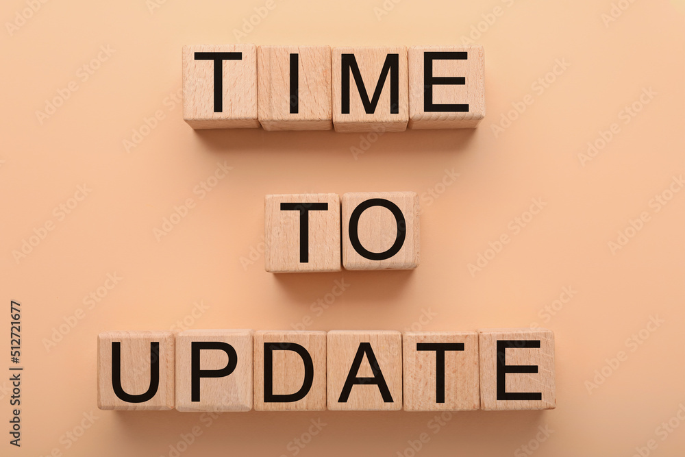 Text TIME TO UPDATE made of wooden cubes on beige background