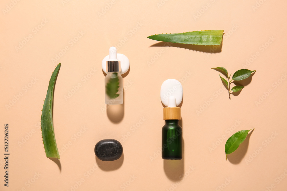 Composition with bottles of natural serum, spa stones and plant leaves on color background