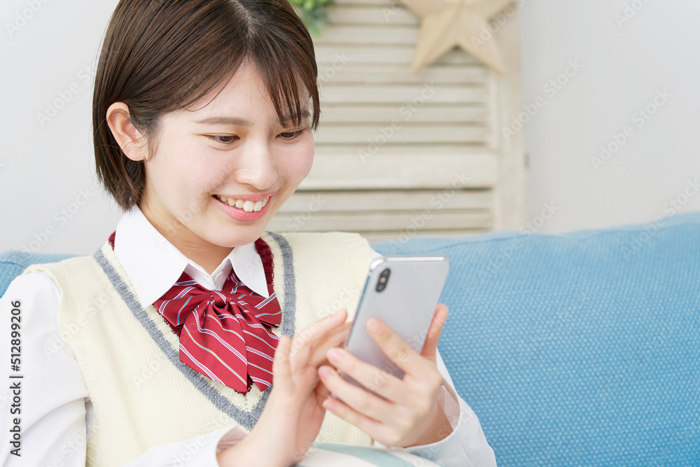 リビングでスマホを使う女子高生