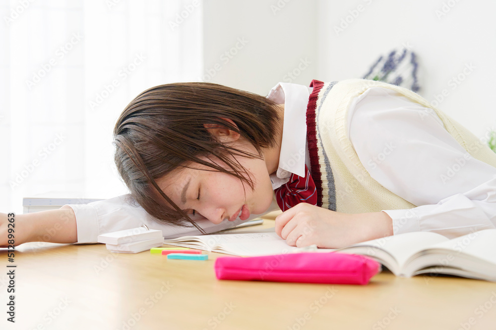 自宅で勉強中に眠る女子高生