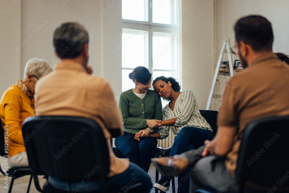 关注一名非洲女性，她把头靠在另一名女性身上，在t处度过了一个艰难的时刻