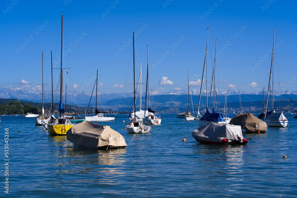 Scenic landscape with moored sailing boats at lakeshore of Lake Zürich at City of Zürich on a sunny 