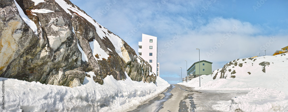 A snowy mountain road or street in a small town or city on a winter day. Empty urban location on a c