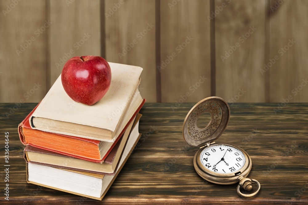 Beautiful old clock, old book on the desk