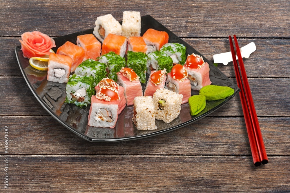 Tray sushi salmon varieties for delivery on a black background.