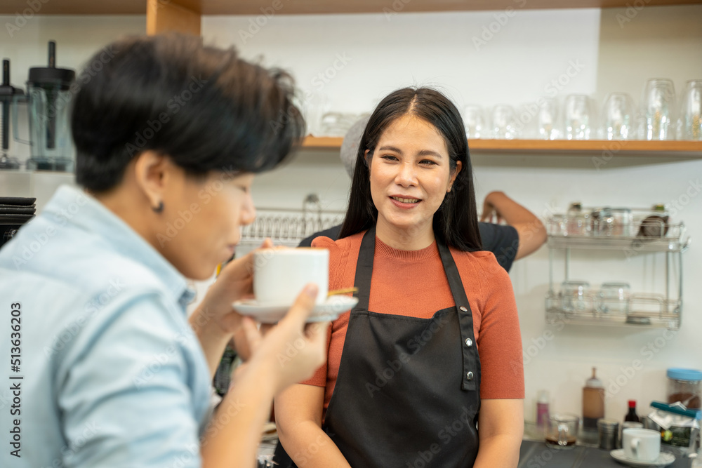 Barista in apron serving customers in coffee shop,Serving customer over the counter.